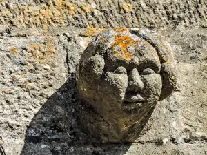 Tête sculptée sur le clocher de l'église (© J.E)