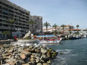 Brunnen und Touristenboot im Hafen von Saint-Cyprien