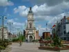 Объектив - Площадь украшена цветами и кустами, домами, церковью Сен-Леже и облаками в небе