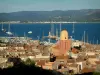 サン・トロペ - 教会の尖塔、旧市街の家の屋根、港、ボート、ヨット、地中海、そして丘の景色