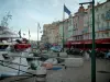 サン・トロペ - 埠頭Jean-Jaurès、フラッグ、レストラン、カフェ、カラフルなファサードの家に停泊しているヨット