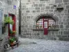 ベッセエサンタナステーズ - 中世とルネッサンスの街：窓が花で飾られた石造りの家。オーヴェルニュ火山の地域自然公園内
