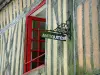 的Domfront - 一个半木料半灰泥的房子门面的细节与红色窗口和锻铁标志的