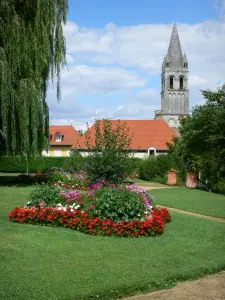 Abadía de Déols - Espadaña de la antigua abadía de Nuestra Señora (el viejo campanario de la iglesia románica de la abadía), Jardín de flores en primer plano