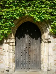 Abadía de Solesmes - Abadía benedictina de Saint-Pierre de Solesmes: puerta de madera de la iglesia de la abadía cubierto con la vid