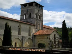 Abbaye de Chancelade - Église, cyprès et nuages dans le ciel bleu