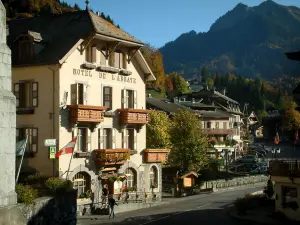 Abondance - Häuser des Dorfes (Wintersportort), Fahnen, Bäume und Berg bedeckt mit Bäumen, im Haut-Chablais