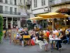 Agen - Place des Laitiers : terrasse de café, statue du pèlerin de Saint-Jacques de Compostelle, boutiques et façades de maisons de la vieille ville