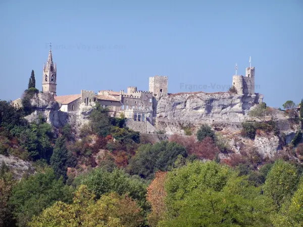 Aiguèze - Espadaña de la iglesia de San Roque, torres y mantener (castillo, fortaleza) de la villa medieval, los árboles en primer plano