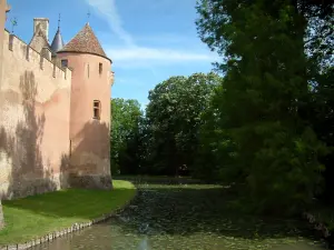 Ainay-le-Vieil castle - Trees, moats with water lilies and tower of the feudal surrounding wall