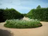 Ainay-le-Vieil castle - Path in the park with flowerbed of white flowers