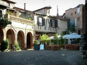 Albi - Piazza pavimentata con un ristorante con terrazza, arbusti e case