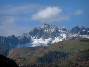 Alpenlandschaften der Savoie - Wald, Alm, Schnee, Gebirgskamm und Wolken im Himmel