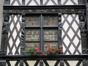 Angers - Fachwerkhaus mit geschnitzten Holzfiguren und sein Fenster dekoriert
mit Blumen