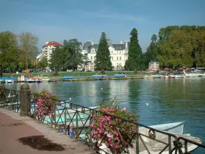 Annecy - Bloemrijk bank (bank) van de tuinen van Europa met uitzicht op het meer Annecy, boten, boten, waterfietsen, de Champ de Mars, bomen en gebouwen in de stad