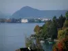 Meer van Annecy - Bomen in de herfst kleuren, huizen aan het meer, gebouwen in de stad Annecy en heuvel op de achtergrond