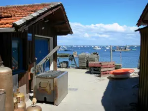 Arcachon bay - Oyster installation in Piraillan, in the town of Lège-Cap-Ferret, and sea dotted with boats 