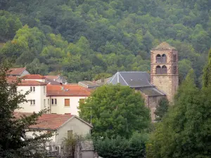 Ardes - Clocher de l'église Saint-Dizaint et maisons du bourg entourés d'arbres ; dans le Parc Naturel Régional des Volcans d'Auvergne