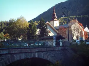 Argentière - Bridge, trees, the Saint-Pierre Baroque church with its bell tower, houses of the village (ski resort) and forest
