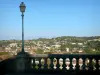 Auch - Lamppost and railing of the monumental staircase in the foreground, view of the Gers valley and the rooftops of the lower town