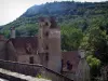 Autoire - Limargue castle with its tower and its corbelled turret, trees and cliff, in the Quercy