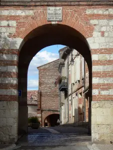 Auvillar - Arnaud puerta de Othon (puerta del reloj) y casas de la aldea en el fondo