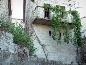 Balazuc - Balkon van een stenen huis versierd met hangplanten