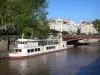 Banks of the Seine river - Cruise ship moored at Quai de Montebello, Double bridge spanning the Seine river, and building facades of the Latin district