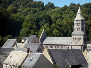 Basilika von Orcival - Achteckiger Glockenturm der romanischen Basilika Notre-Dame, Häuserdächer des Dorfes und Bäume; im Regionalen Naturpark der Vulkane der Auvergne, im Bergmassiv Dore