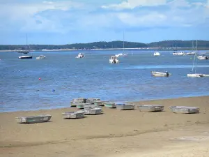 Bassin d'Arcachon - Coques d'optimists du club de voile sur la plage d'Andernos-les-Bains avec vue sur les bateaux flottant sur les eaux du bassin d'Arcachon