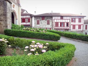 La Bastide-Clairence - Fiore giardino della chiesa e le case con le persiane rosse letti Navarra Paese