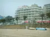 O baule - Praia de areia com barcos e edifícios da estância balnear