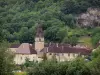 Baume-les-Messieurs - Abadía: edificios de la abadía, el campanario de la iglesia de la abadía de Saint-Pierre y árboles