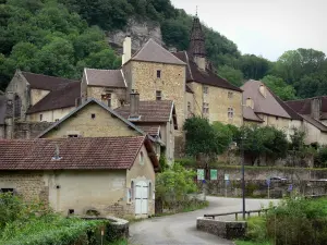 Baume-les-Messieurs - Rue, maisons, abbaye avec ses bâtiments abbatiaux et le clocher de l'église abbatiale Saint-Pierre, arbres