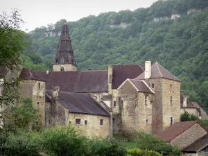 Baume-les-Messieurs - Abbey, con sus edificios de la abadía y la torre de la iglesia de la abadía de Saint-Pierre, los árboles