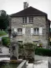 Baume-les-Messieurs - Fountain, bloemen en stenen huis