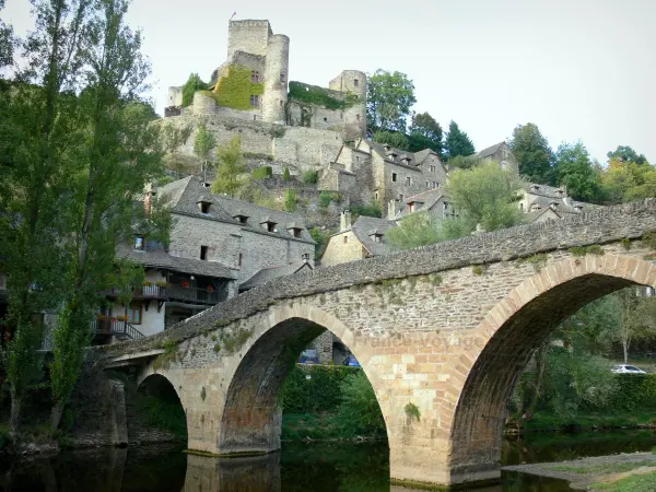 Belcastel - Old bridge spanning River Aveyron, houses of the medieval village and Belcastel castle dominating the place