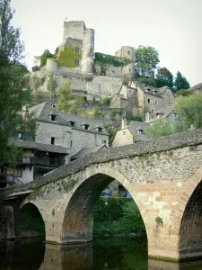 Belcastel - Old bridge spnning River Aveyron, houses of the medieval village and Belcastel castle dominating the place