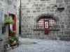 Besse-et-Saint-Anastaise - Casas de piedra medieval y renacentista con ventanas adornadas con flores en el Parque Natural Regional de los Volcanes de Auvernia