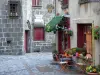 Besse-et-Saint-Anastaise - Fachadas medievales y del renacimiento de las casas como un decorado con flores en el Parque Natural Regional de los Volcanes de Auvernia