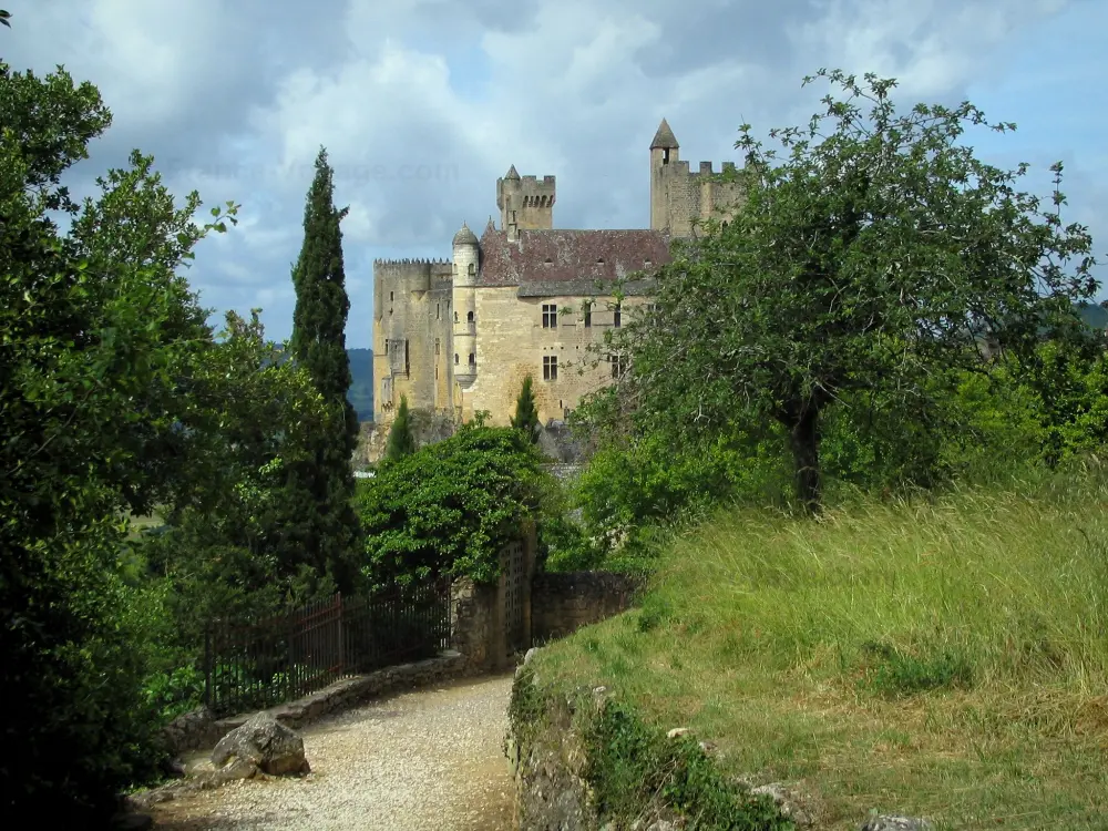 Beynac-et-Cazenac - Petit chemin bordé d'arbres menant au château, ciel nuageux, dans la vallée de la Dordogne, en Périgord