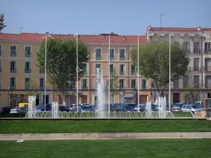 Béziers - Immeubles de la ville, platanes (arbres), fontaine à jets d'eau et pelouses