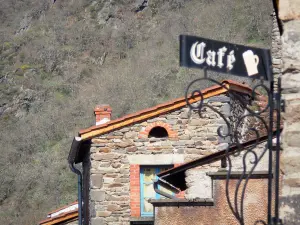 Blesle - Wrought iron sign of a café and houses of the village