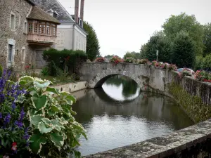 Bonneval - Pont fleuri enjambant le fossé en eau, maisons du village au bord de la rivière Loir, fleurs, arbres ; dans la Beauce