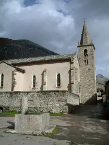 Bonneval-sur-Arc - Brunnen und Kirche des savoyard Dorfes mit einem bewölkten Himmel, in der Haute-Maurienne (Nationalpark Vanoise)