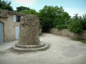 Bonnieux - Place avec construction en pierre, maison et arbres