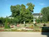 Bourges - Allée, parterres fleuris, statue et arbres du jardin de l'Archevêché, édifices en arrière-plan
