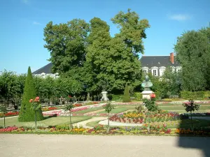 Bourges - Acera, macizos de flores y árboles de la estatua del jardín de la Arquidiócesis, los edificios en el fondo