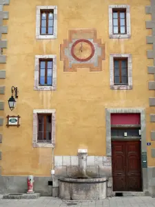 Briançon - Ciudad Alta (Ciudadela Vauban Vauban ciudad): colorida fachada decorada con un reloj de sol y una fuente en la Plaza de Armas