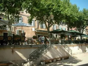 La Cadière-d'Azur - Treppen, Kaffeeterrassen, Sonnenschirme, Platanen (Bäume) und Häuser des mittelalterlichen Dorfes